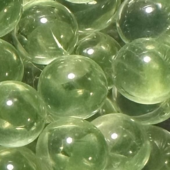 Peridot 10mm: kleine Murmel aus durchscheinend hellgrünem Glas