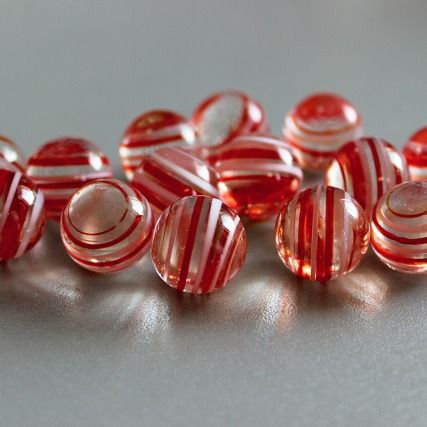 Zuckerstange 16mm: Glasmurmel aus klarem rosa Glas mit roten und weißen Streifen