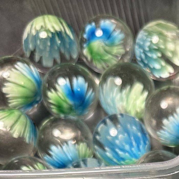 Blüte grün-blau 25mm: handgefertigte Glasmurmel aus klarem Glas mit Blüte in Grün und Blau