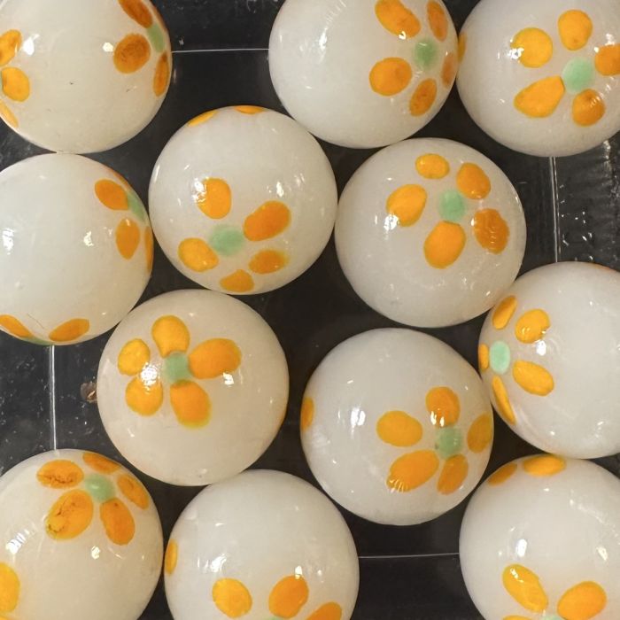 Frühling weiß-orange 16mm: handgefertigte Glasmurmel aus milchweißem Glas mit orangefarbenen Blümchen mit hellgrünem Herz